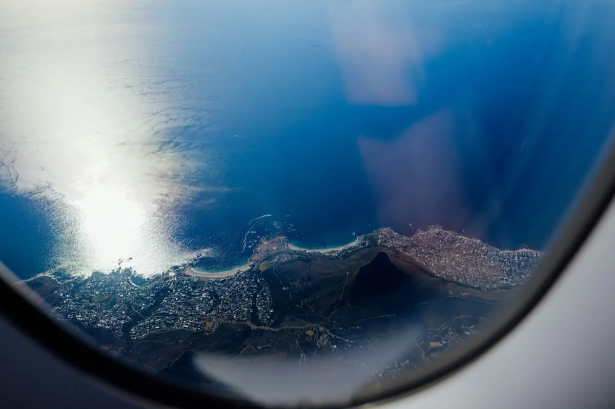 A coastline seen from an airplane window on approach, the moment Italian tax residency starts counting