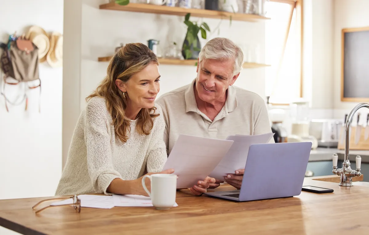 A couple reviewing financial documents together at their kitchen counter